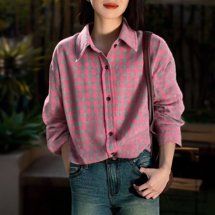 Woman wearing a pink and grey plaid brushed cotton shirt with a relaxed fit, POLO collar, and buttoned cuffs, styled with blue jeans and a brown crossbody bag in an outdoor setting.