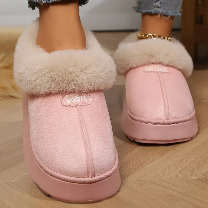 Chic pink mule slippers featuring a plush faux fur trim and a matte suede-like upper with an embroidered &