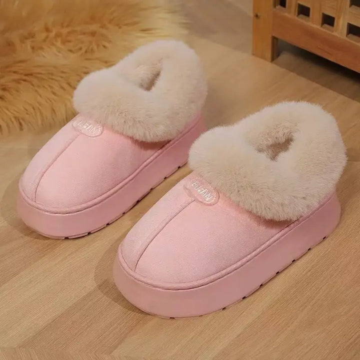 Chic pink plush mule slippers with a thick platform sole and soft faux fur trim, showcasing the &