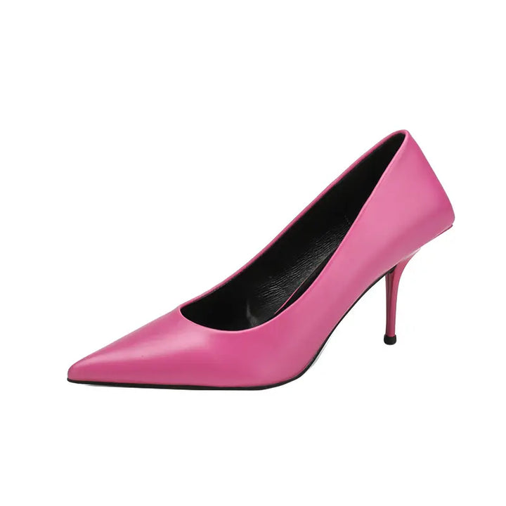 Vivid pink high-gloss faux leather stiletto heels with a sharp pointed toe and sculpted heel base, displayed from a front three-quarter angle.