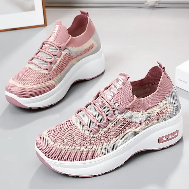 Three-quarter view of blush pink engineered knit platform trainers with a striped pattern, featuring grey laces, a chunky white sole, and &