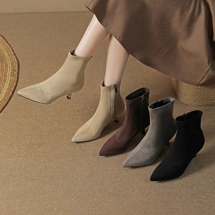 Collection of four chic pointed-toe stiletto ankle boots in black, taupe beige, dark brown, and grey, shown on a model&