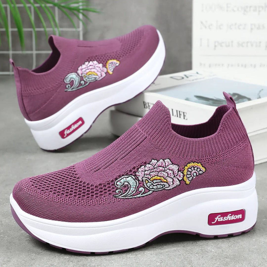 Purple knit slip-on sneakers with embroidered floral motifs and a white platform sole featuring a pink 'fashion' logo detail.
