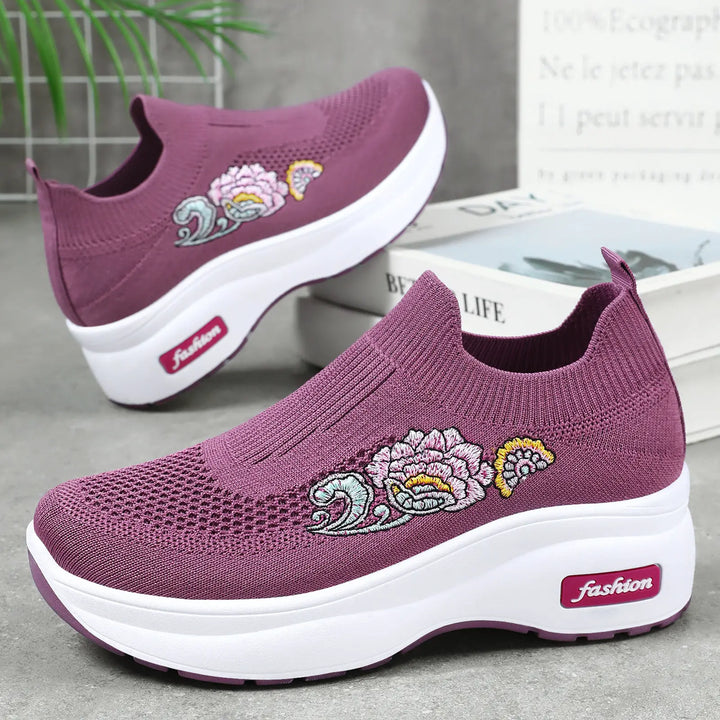 Purple knit slip-on sneakers with embroidered floral motifs and a white platform sole featuring a pink &