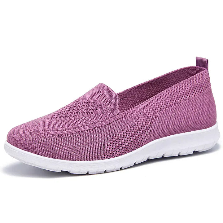 Purple breathable knit slip-on trainers for women, featuring a subtle diamond weave pattern on the vamp, a rounded toe, and a clean white sole with a heel loop.