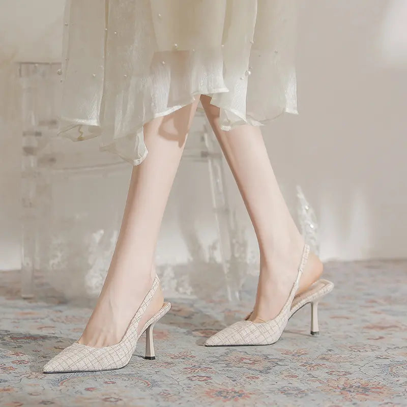 Elegant Qalani pointed-toe slingback heels in a textured beige tweed-like fabric, shown on a model&