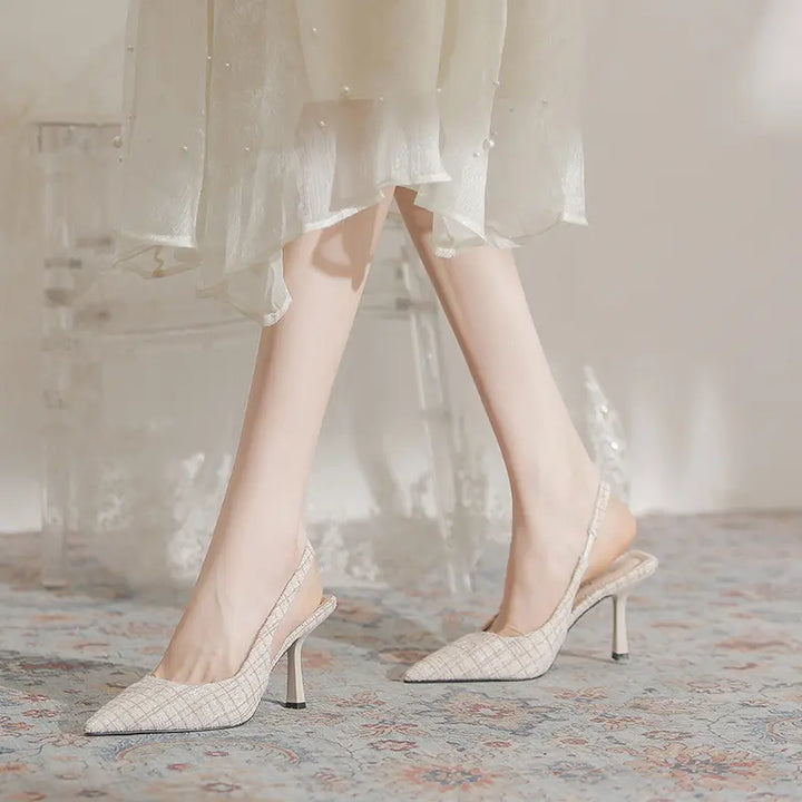 Elegant Qalani pointed-toe slingback heels in a textured beige tweed-like fabric, shown on a model&