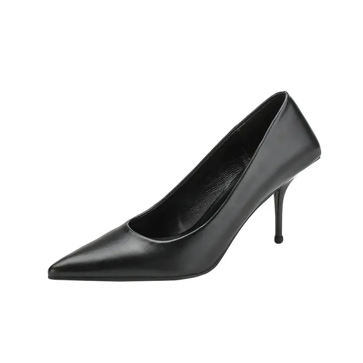 Side view of a black Qanari stiletto heel featuring a sharp pointed toe, high-gloss faux leather, and a slender sculpted heel.