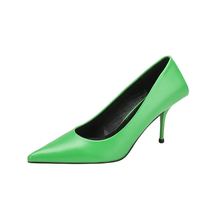 Qanari vivid green high-gloss faux leather stiletto heels with a sharp pointed toe and sculpted heel base, shown from the side.