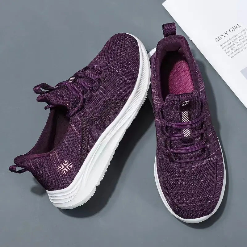 Pair of Qanik deep purple breathable mesh athletic trainers shown from a top-down, three-quarter angle with white sculpted soles and flat tonal laces.