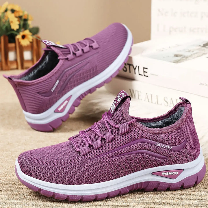 Purple knit Qorto winter sneakers with plush faux fur lining, shown from a three-quarter angle with white midsoles and matching purple outsoles.