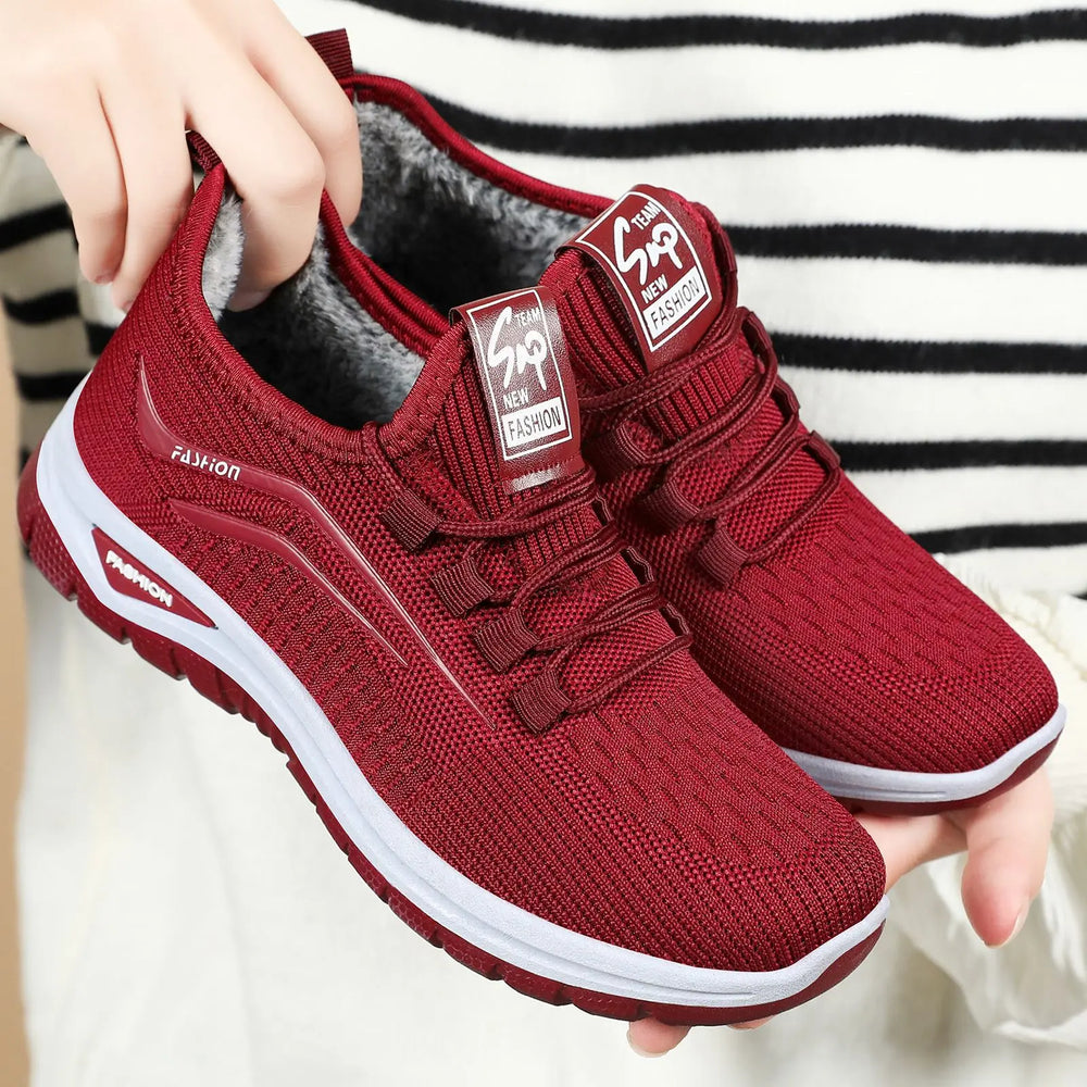 Three-quarter view of Qorto warm winter sneakers in deep red knit with white midsole and matching red outsole, showcasing plush faux fur lining and lace-up closure.