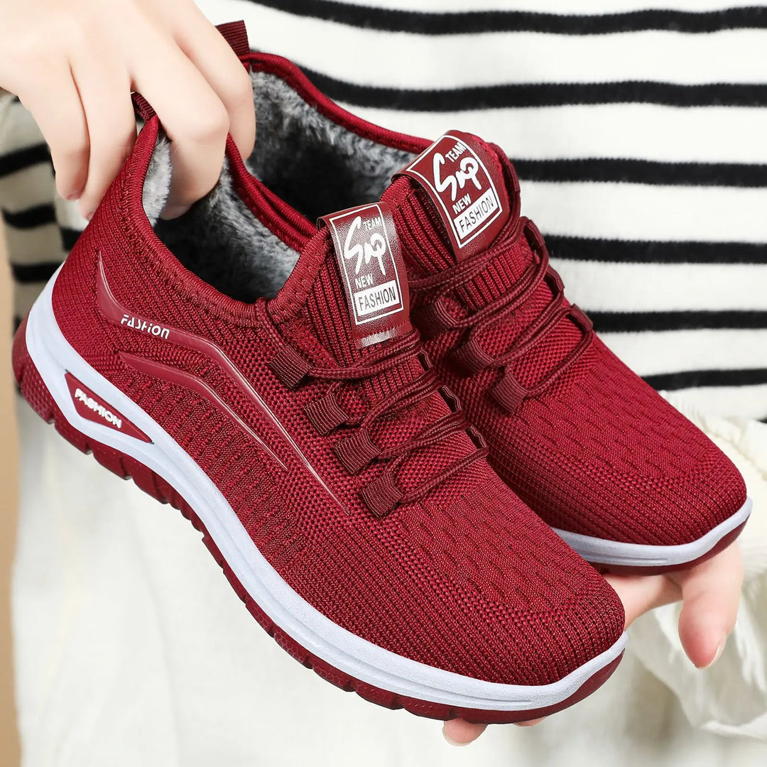 Three-quarter view of Qorto warm winter sneakers in deep red knit with white midsole and matching red outsole, showcasing plush faux fur lining and lace-up closure.