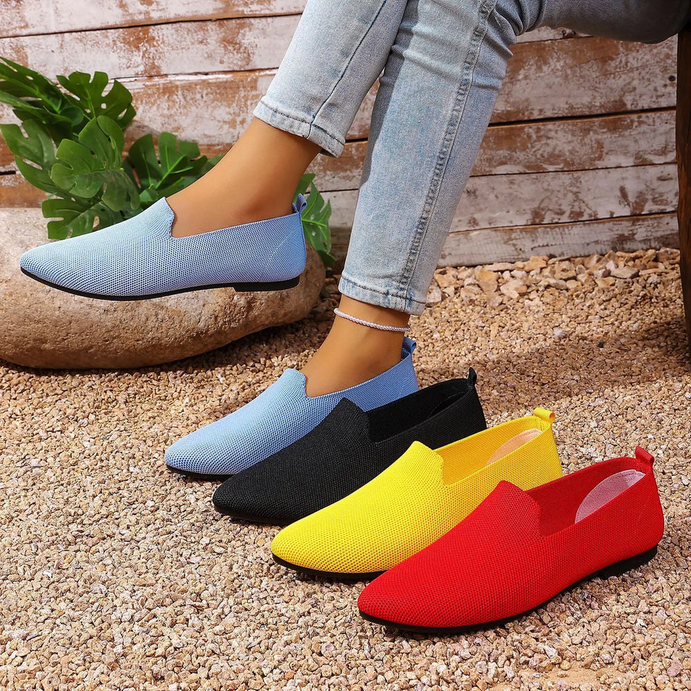 Quoris women's breathable knitted pointed toe flats displayed in multiple vivid colors including blue, black, yellow, and red, with one pair shown worn on a model's feet.