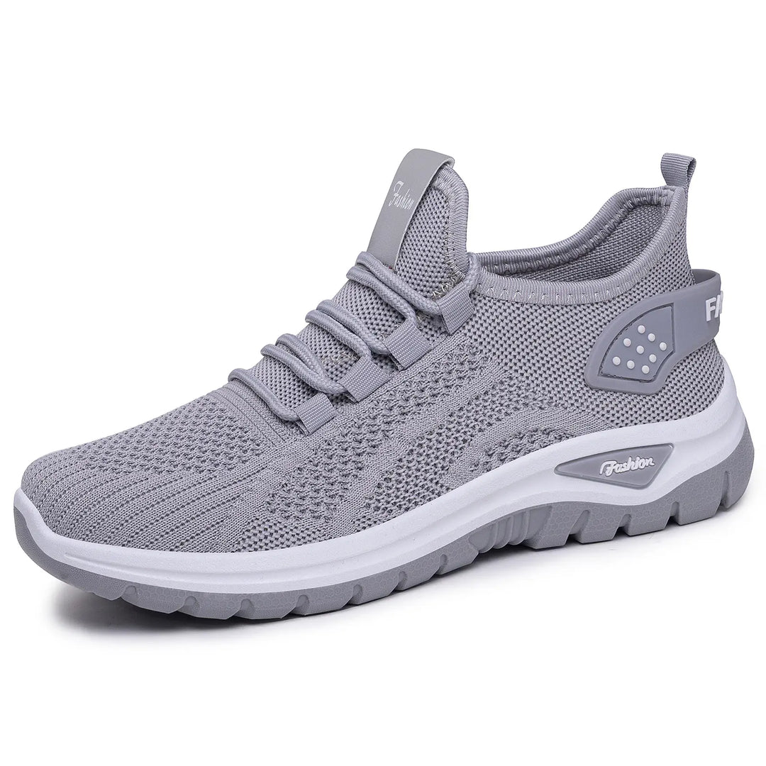 Grey Raxen breathable mesh sneakers in a front-three-quarter view, showcasing their lightweight design, comfortable cushioning, and subtle &