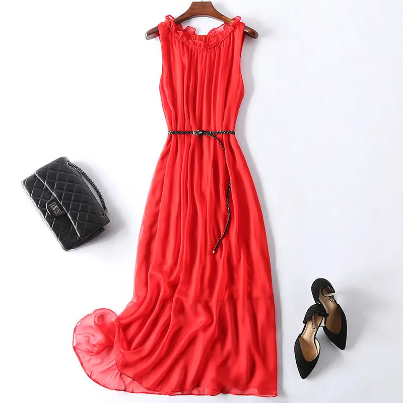Red sleeveless pure silk midi slip dress with ruffled neckline and braided black belt, styled with a handbag and heels on a white background.