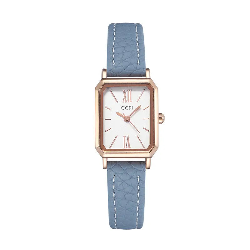 Rose gold rectangular watch with a white dial featuring Roman numerals, and a light blue faux leather strap with white contrast stitching.