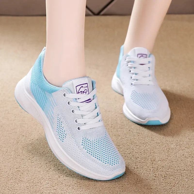 Rylux breathable knit sneakers in white and light blue, shown on feet from a three-quarter front view, highlighting the adaptive fit and lightweight design.