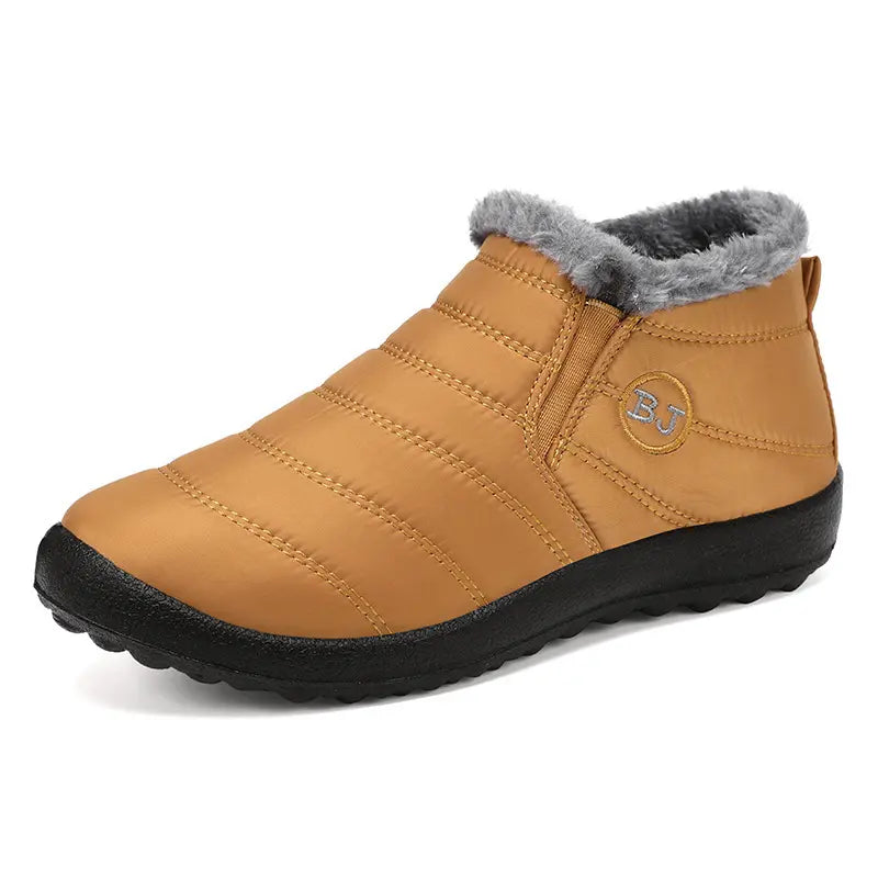 Tan quilted waterproof winter ankle boot with plush grey faux fur trim, elasticated side gore, and a round toe, displaying the outer side and front.