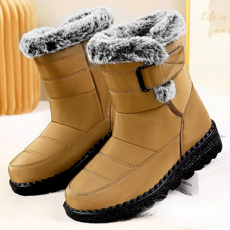 Tan quilted mid-calf winter boots with plush faux fur trim and collar, featuring a side strap with a matte black buckle and a chunky lugged rubber sole.