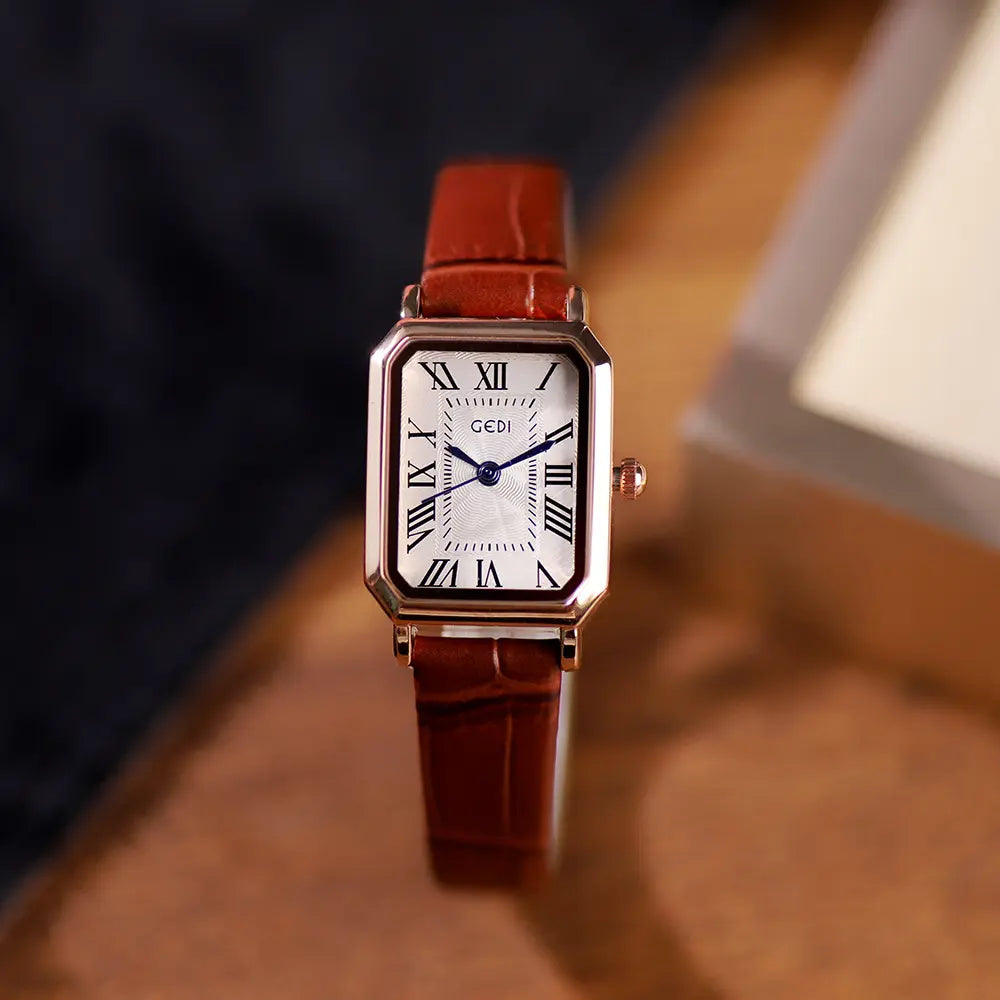 Tarkhan rectangular rose gold watch with a white dial, Roman numerals, blue hands, and an embossed brown leather strap.