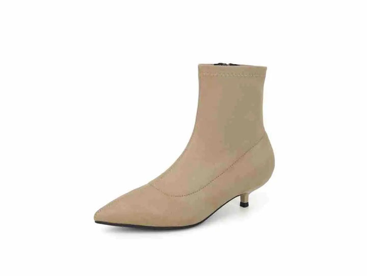 Taupe beige stiletto ankle boot with a pointed toe, stretch sock-like shaft, and subtle side zipper, presented on a clean white background.