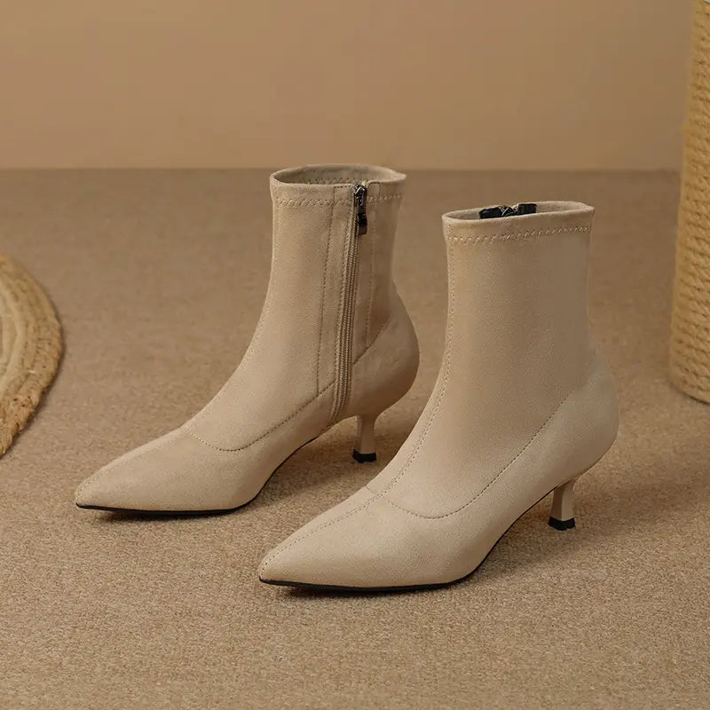 Taupe beige suede-like ankle boots with pointed toes, slender stiletto heels, and inner side zippers, shown from the front.