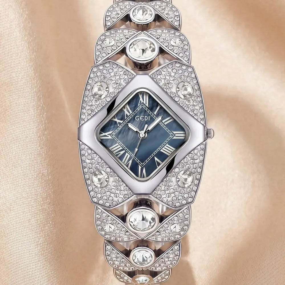 A luxurious silver-tone Tavril diamond-embellished bracelet watch with a blue mother-of-pearl rhombic dial featuring Roman numerals.