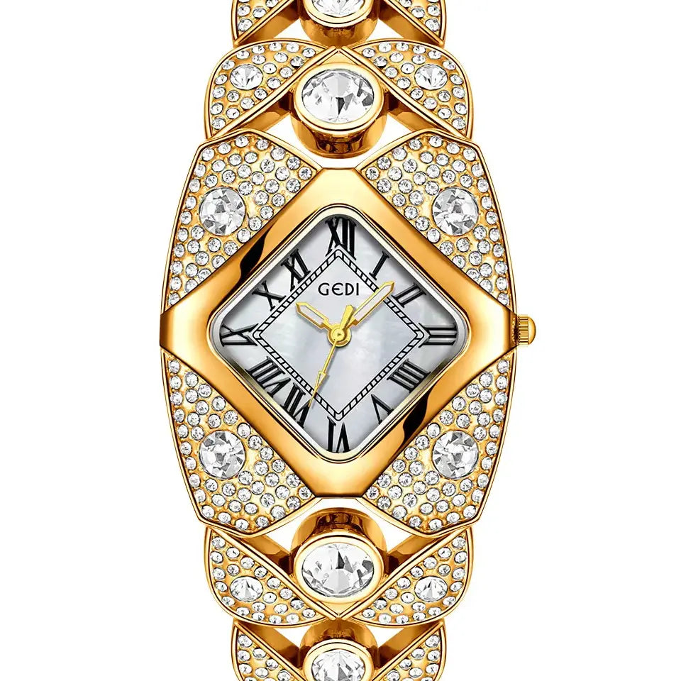 Gold-tone Tavril diamond-embellished bracelet watch featuring a rhombic case, mother-of-pearl dial with Roman numerals, and a crystal-encrusted sculptural metal band. The watch is displayed on a white background.