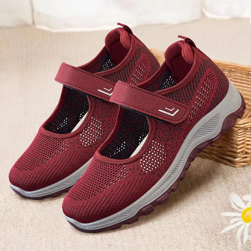 A pair of women's Torvik breathable comfort sneakers in burgundy, featuring a marled knit mesh upper, adjustable hook-and-loop straps, a sculpted grey midsole, and a plum purple rubber outsole. These casual walking shoes are shown from a three-quarter front angle.