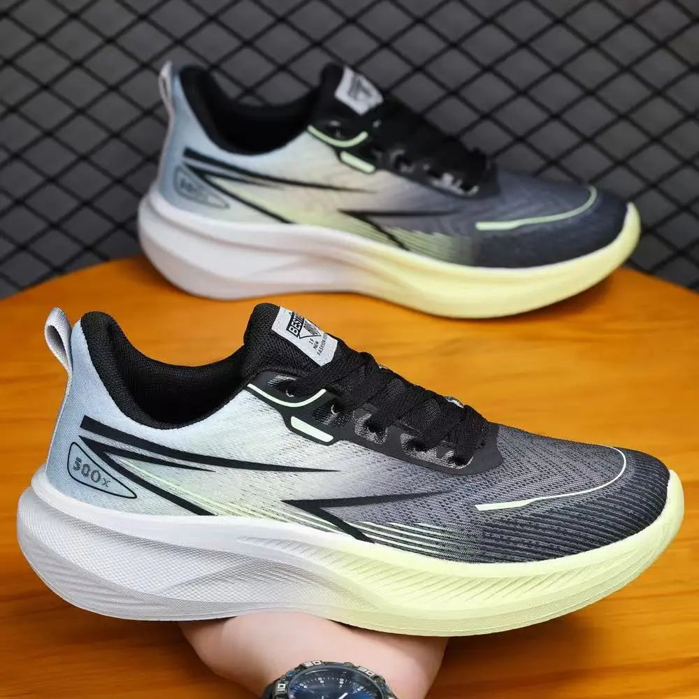 Torvin men's athletic trainers in black with white side accents and grey gradient, shown in a three-quarter view on a wooden surface with a second pair in the background.