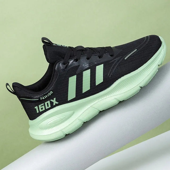 Black unisex low-top athletic sneakers with mint green stripes and sole, featuring &