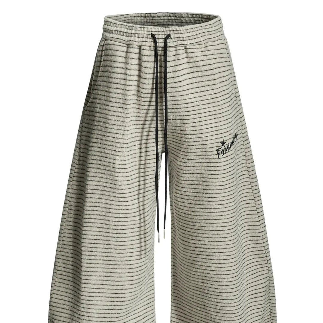 Beige unisex retro wide leg trousers featuring fine horizontal stripes, a high drawstring waist, and embroidered hip detail.