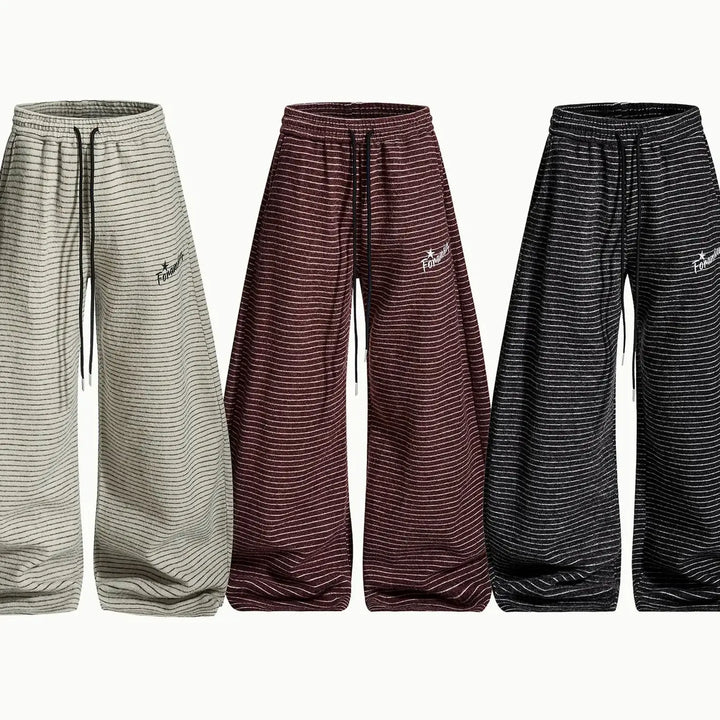 Three pairs of Vazel Retro Wide Leg Trousers in beige, muted burgundy, and charcoal black, showcasing their fine horizontal stripes, oversized fit, and drawstring waistbands.