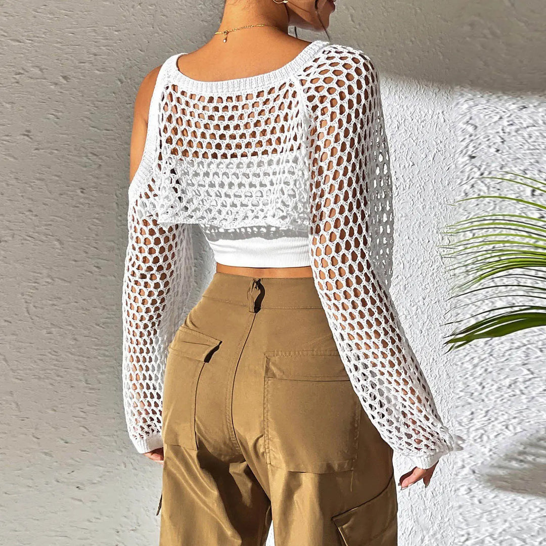 Back view of a white open-knit crochet crop top with cold-shoulder design and voluminous sleeves, worn over a white underlayer with brown cargo pants.