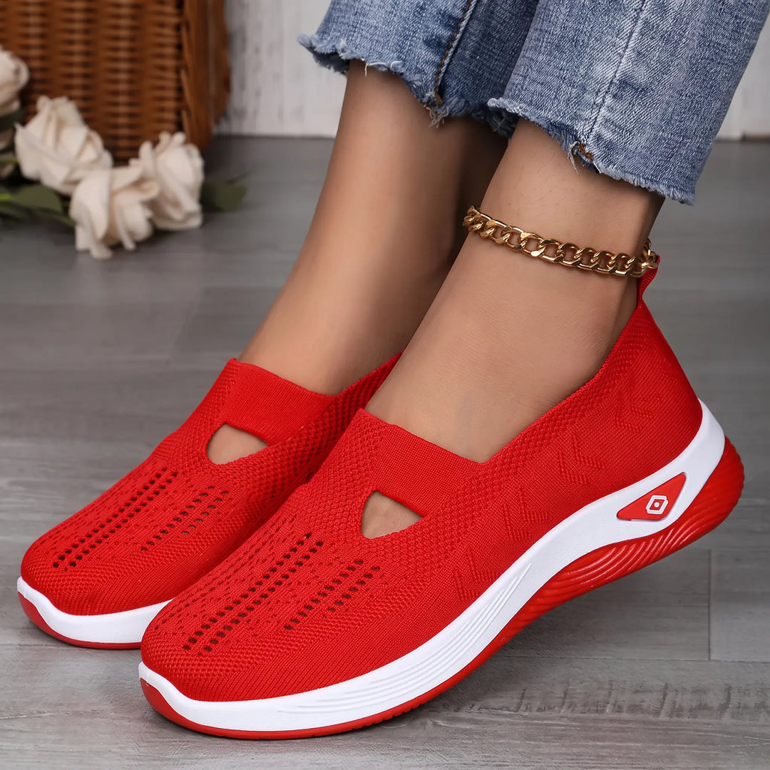 Vespera breathable mesh slip-on trainers for women shown in black and vibrant red color options on a studio floor.