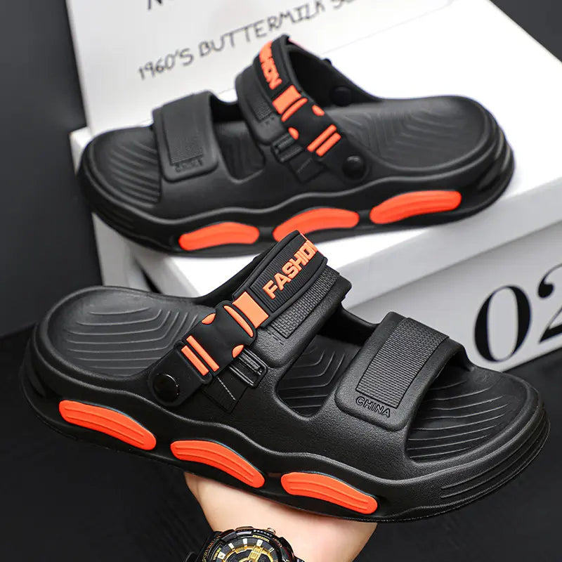 Black men's Vespyr slide sandals with bright orange sole accents and adjustable straps featuring 'FASHION' and 'CHINA' embossing.