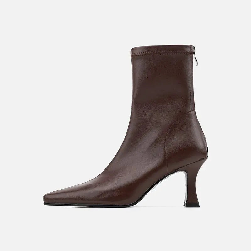 Side view of a rich chocolate brown Vesryn stiletto ankle boot featuring a sharp pointed toe, smooth synthetic leather, and a distinctive sculptural flared heel.