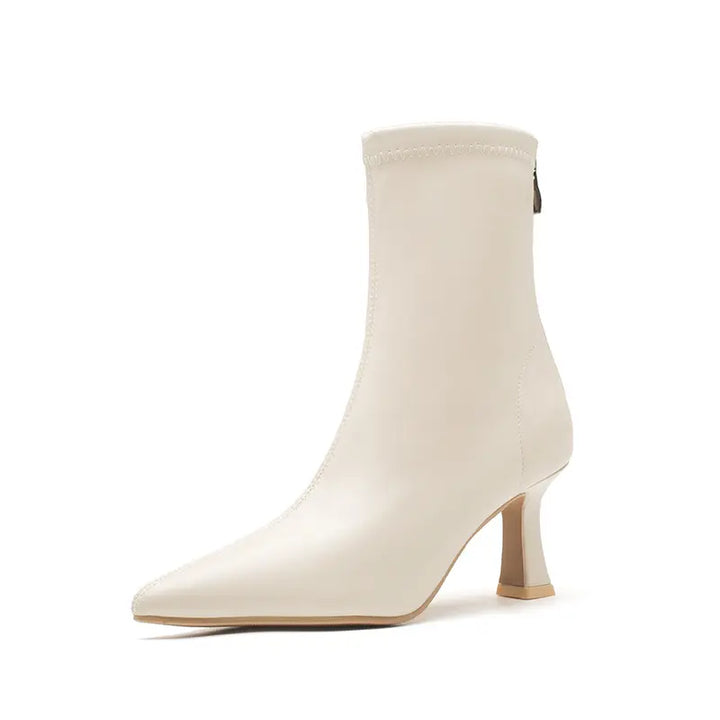 Vesryn chic pointed toe stiletto boots in creamy off-white, showcasing a sharp pointed toe, sculptural flared heel, and fitted mid-calf shaft with a rear zipper.