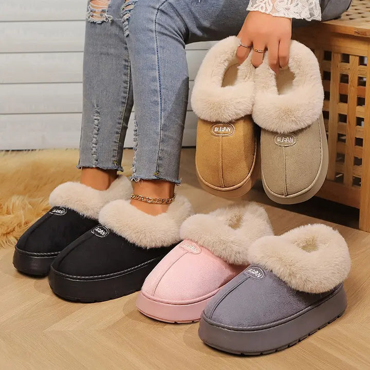 Cozy Vexel mule slippers in multiple colors: warm camel, pink, grey, and black, featuring plush faux fur lining and a thick EVA platform sole. One pair is worn by a person with ripped jeans.