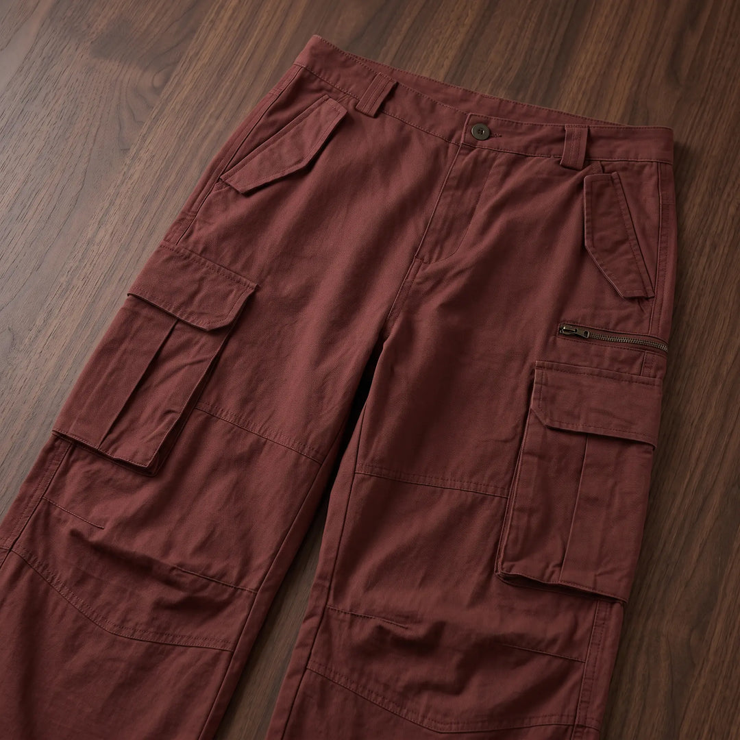 Vextar relaxed fit, wide-leg cargo pants in terracotta rust cotton twill, displayed in a flat lay showing multiple buttoned flap pockets and a thigh zipper.