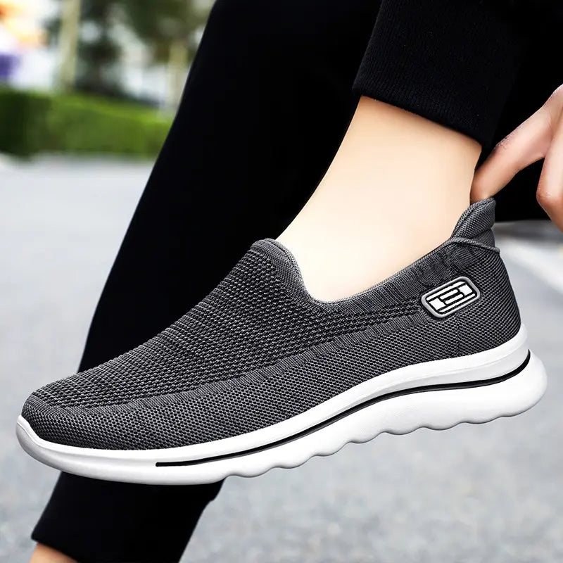 Dark grey Veyla comfort knit slip-on trainers shown from the side on a person&