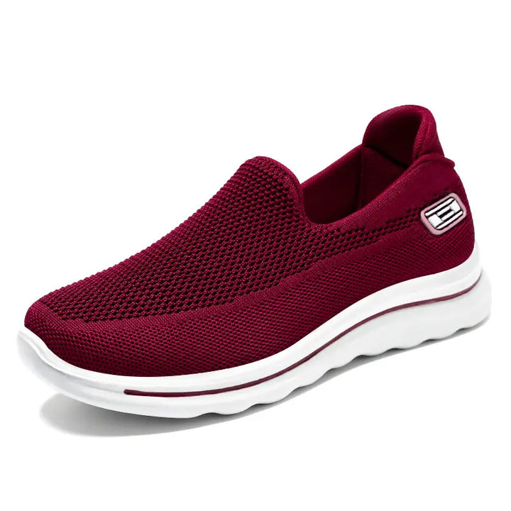 Veyla Comfort Knit Trainers in deep red, presented from a side view on a clean white background, showcasing the breathable mesh knit texture and a sculpted white sole with a subtle accent line.