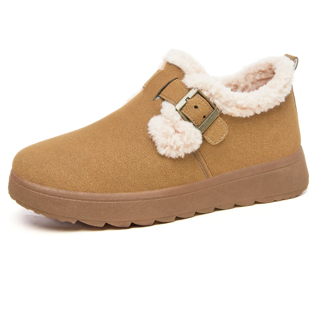 Brown Vylos suede-like winter boot with plush faux fur lining, adjustable decorative buckle strap, and a matte lugged sole, shown from the side.