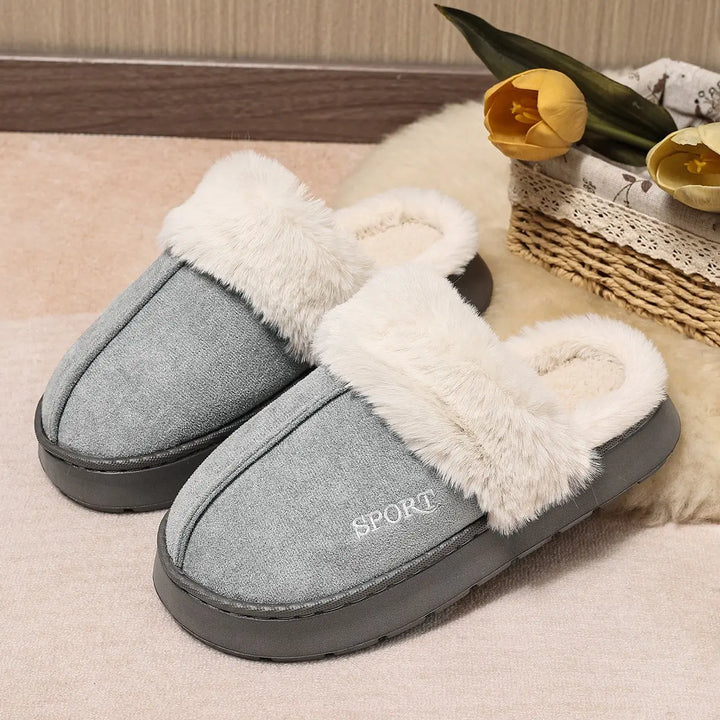 Pair of Vyxen medium grey mule slippers with plush white faux fur trim and lining, featuring a subtle embroidered &