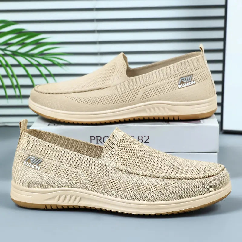 Two warm sand knit slip-on shoes shown from a three-quarter angle, featuring breathable mesh uppers, flat textured rubber soles, and subtle side logos.