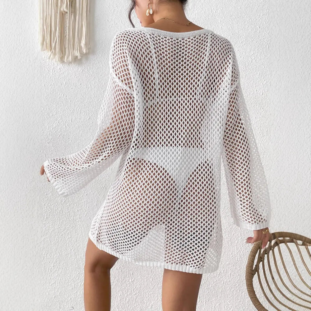 Back view of a white open-knit mesh V-neck beach cover-up with flared sleeves and high side slits, worn by a model over a white bikini.