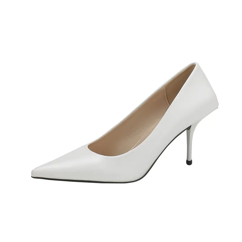 A pair of white high-gloss faux leather stiletto heels with a sharp pointed toe and a slender sculpted heel, presented on a clean white background.