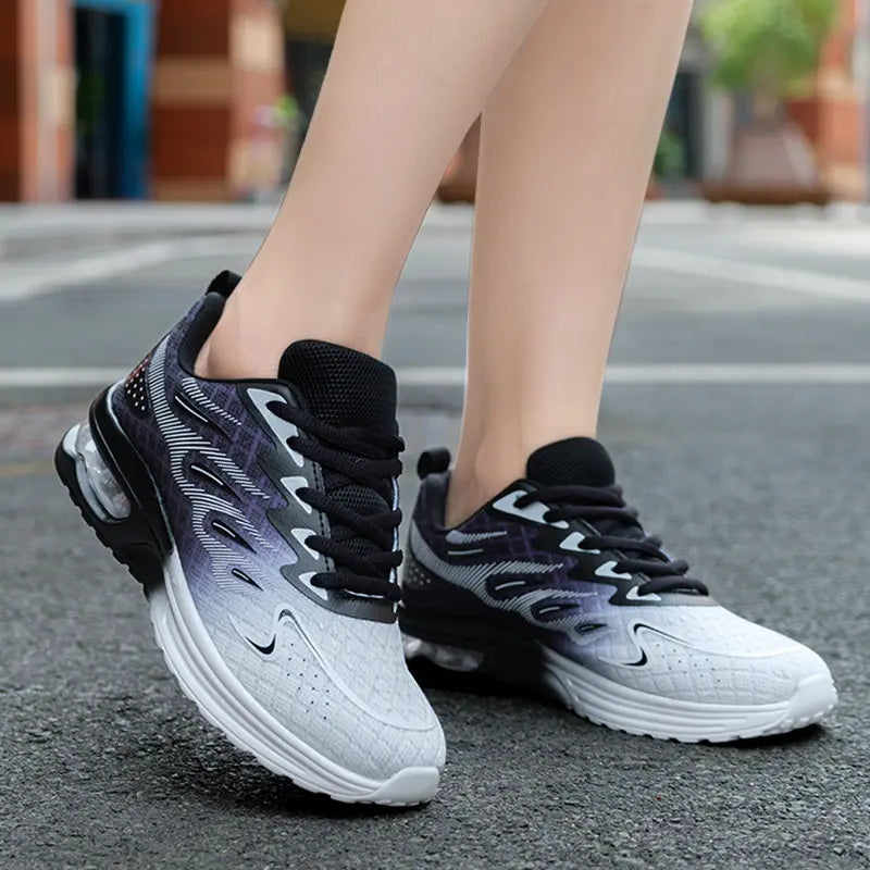 Women's Goruna gradient breathable running trainers worn on feet, showcasing a three-quarter view with a subtle black and grey ombre effect on a blurred urban street.