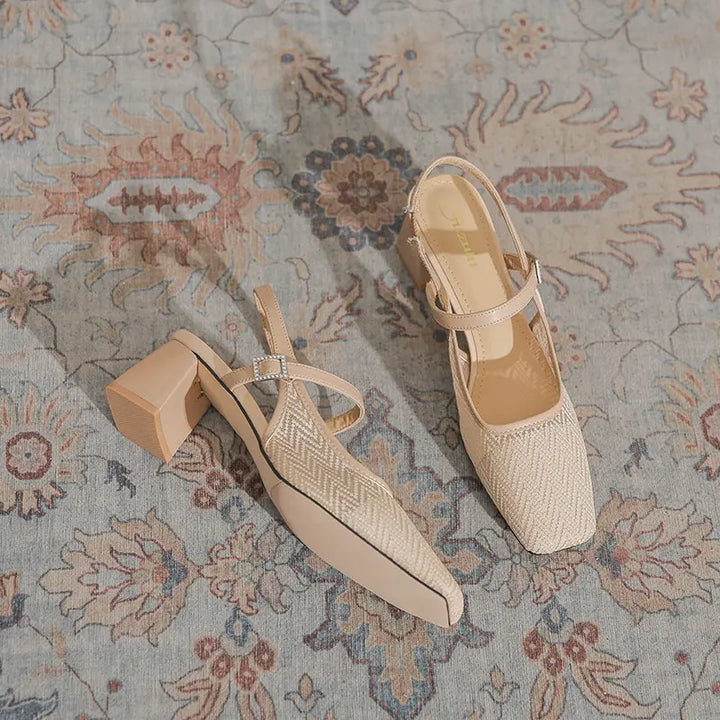A pair of chic Xylia heeled slingback sandals in beige, featuring a square toe, woven mesh vamp, and block heel, laid on a patterned rug.